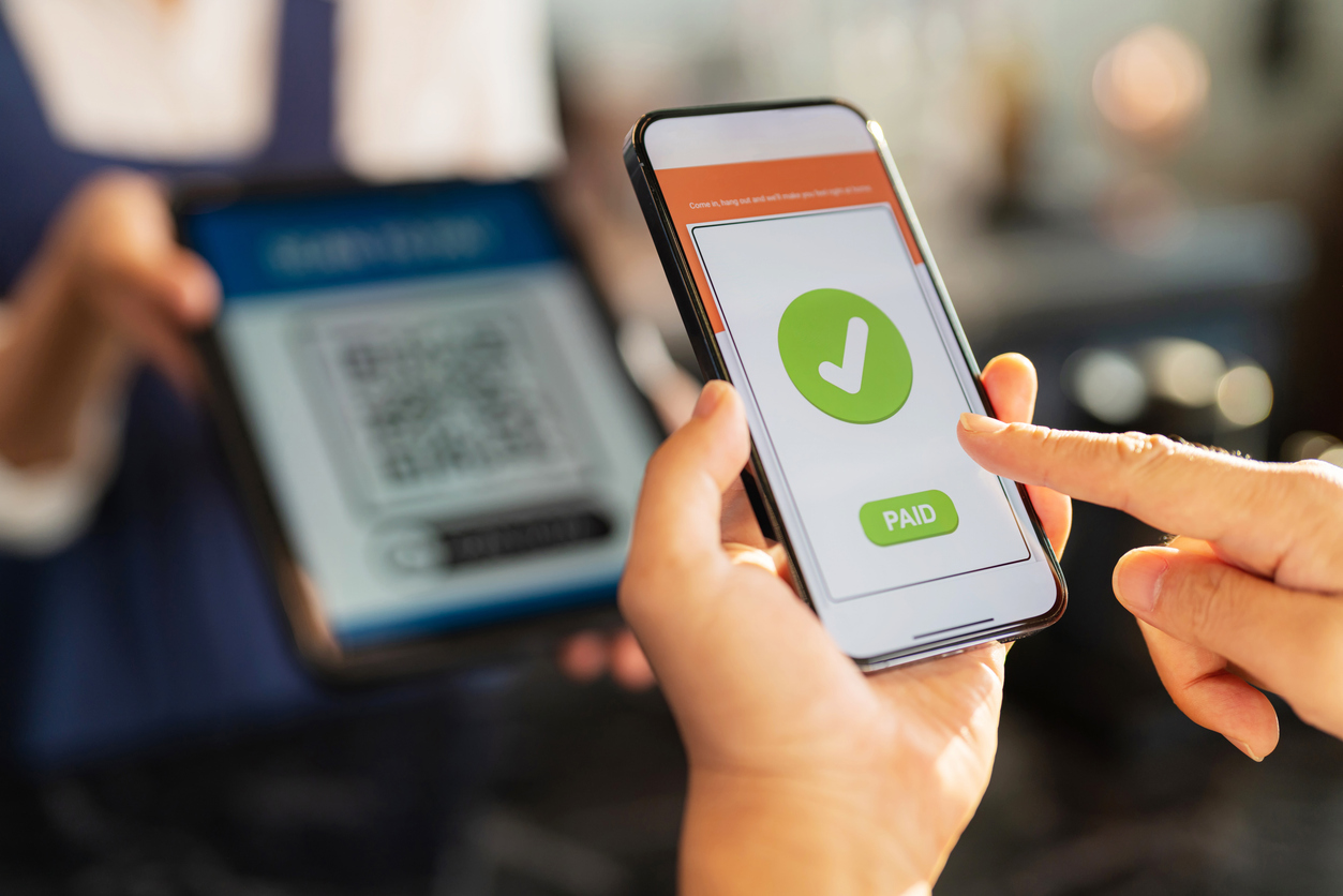 Customer hand using smartphone to do payment at coffee shop restaurant. Digital mobile phone scan QR code for buying coffee. Cashless technology and money transfer concept. New lifestyle and wifi technology